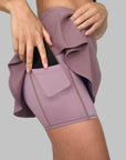 Sidovy av Maya Ribbed Skirt i dusty purple där modellen demonstrerar användningen av mobilfickan.