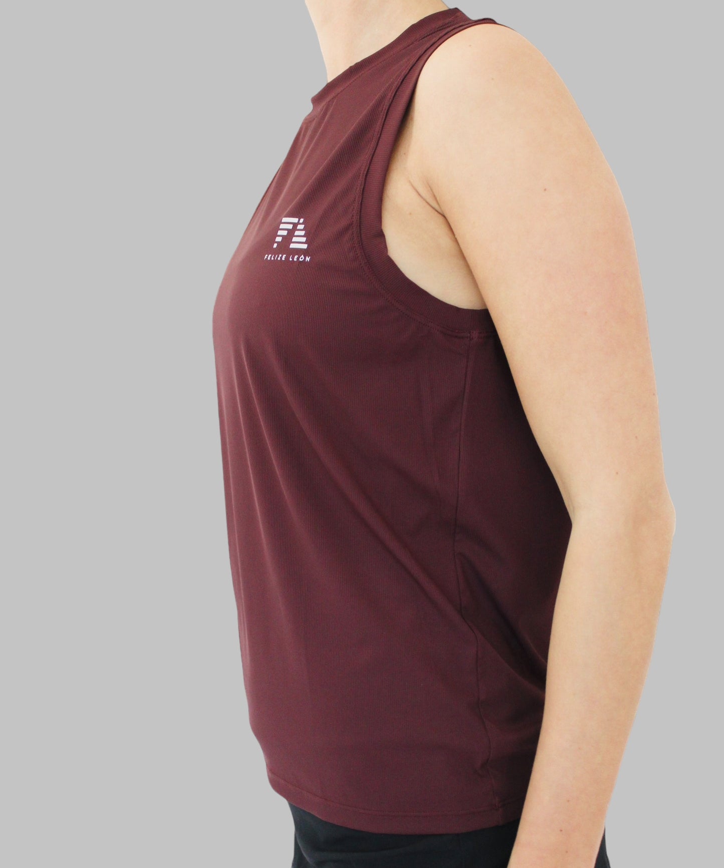 sidovy av CLEO Performance Tank Top i färgen burgundy. Denna topp har en avslappnad passform och är tillverkad i ett silkeslent material som andas och håller dig sval och torr.