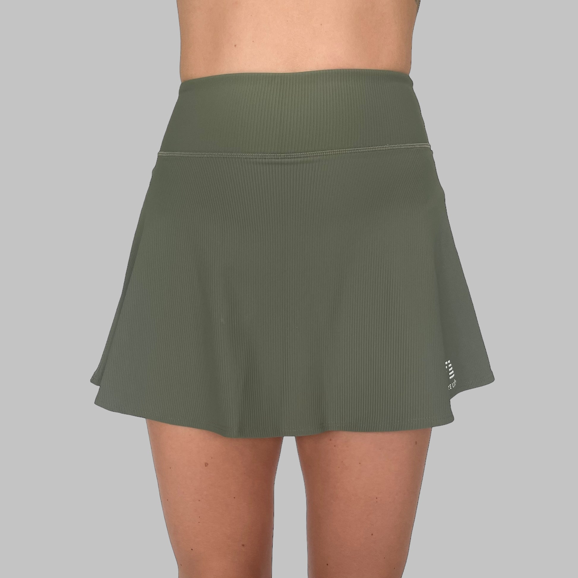 Frontvy av Maya Ribbed Skirt i army green, framhäver kjolens höga midja och moderna ribbade design, mot en enfärgad bakgrund.