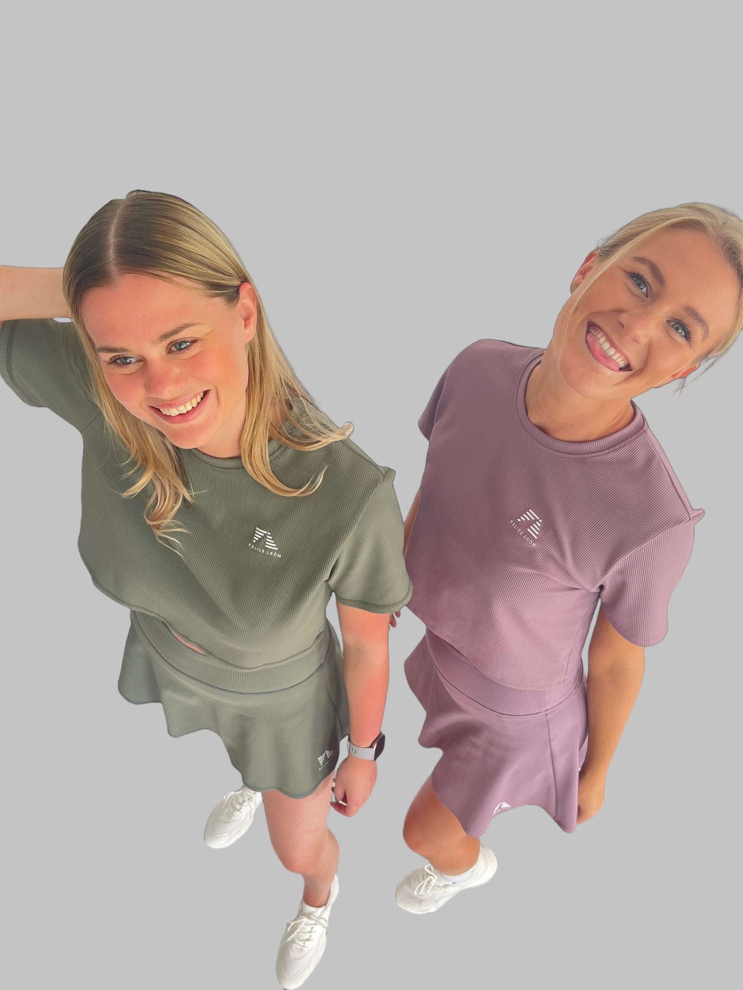 Två glada modeller poserar tillsammans, bär ett varsitt set ur ribbed collection, padelkjolar i olika färger och matchande toppar till. 