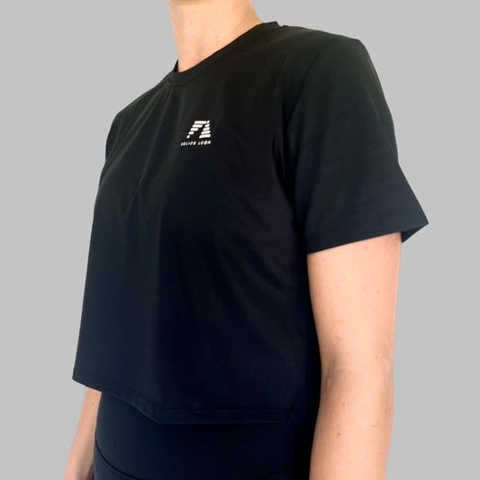 Sidovy av Zara Classic Cropped T-shirt i svart, med logotypen synligt på bröstet, visar den avslappnade men ändå skräddarsydda passformen.