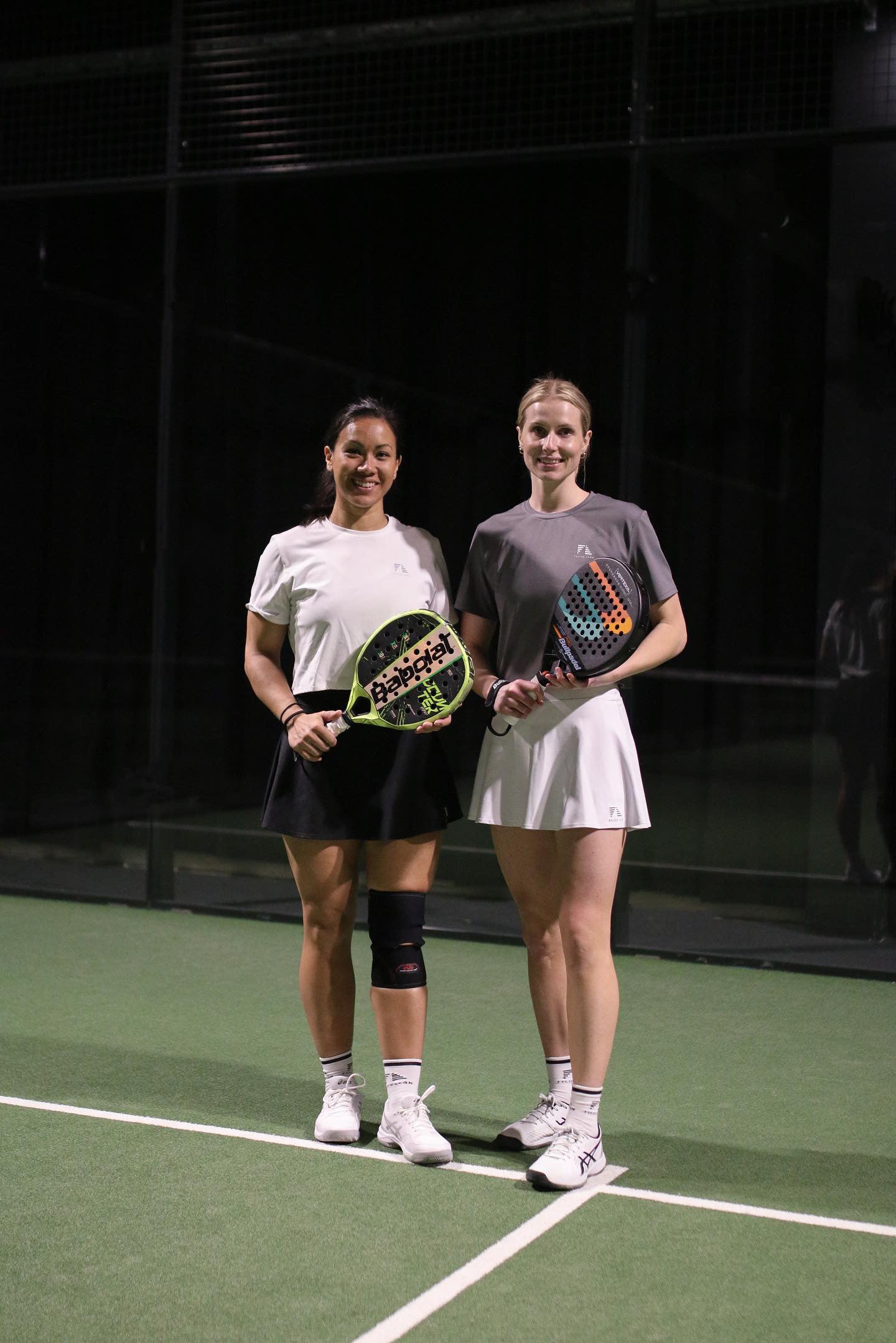 Kvinnor på padelbana i Zara Classic Cropped T-shirt i grått och vitt, håller i ett padelrecket.